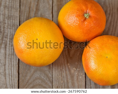 Three big grapefruits on the wooden board.