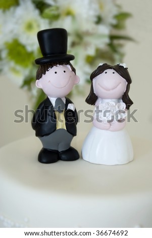 stock photo Bride and groom figurines on top of a wedding cake