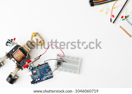 A metal robot and an electronic board that can be programmed. Robotics and electronics. Lab in the school. Mathematics, engineering, science, technology, computer code. STEM education for kid.