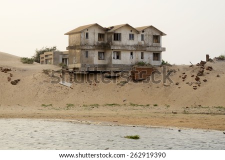 Sea level rising causing soil erosion in the costal belt which cause damage to human and his livelihood and property, a house is hanging dangerously on June 28, 2014 in Odisha, India