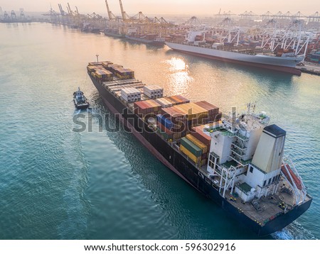 commercial vessel container ship in proceeding arrival to the port channel due, assist by the tugs boat for safety entrance gateway of the port