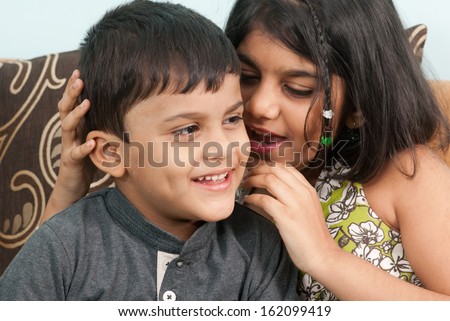 Indian girl whispers boy in the ear secret children gossip
