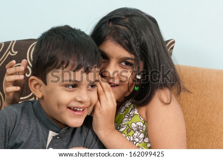 Indian girl whispers boy in the ear secret children gossip