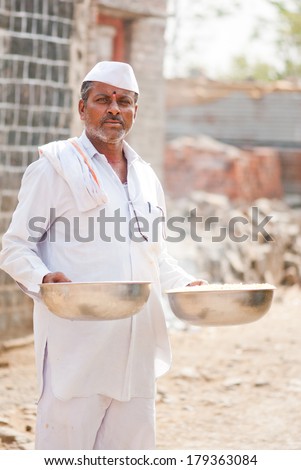 man with two stainless steel basket in hand rural village Salunkwadi, Beed, Maharashtra, India