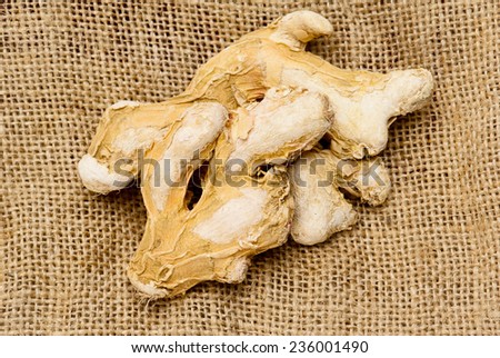 Dry ginger root on burlap cloth background