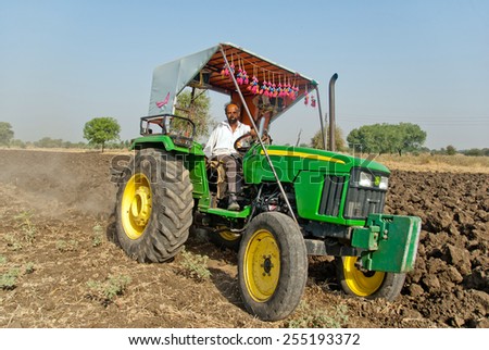 BEED, MAHARASHTRA, INDIA - March 25, 2012: Farmer in tractor preparing land for sowing rural village Salunkwadi