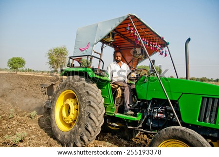 BEED, MAHARASHTRA, INDIA - March 25, 2012: Farmer in tractor preparing land for sowing rural village Salunkwadi