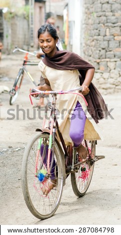 MAHARASHTRA, INDIA SEPTEMBER 22, 2011: Indian rural girl rides her bicycle, SEPTEMBER 22, 2011, rural village, Salunkwadi, Ambajogai, Beed, Maharashtra, India
