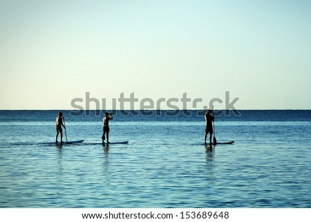 Three Men Paddle-Boarding At Caribbean Sea