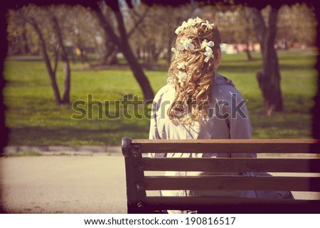 Woman sitting alone on bench. vintage photo