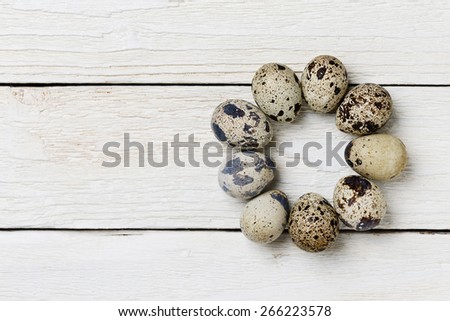 Circle of the quail eggs on the wooden table. Top view.