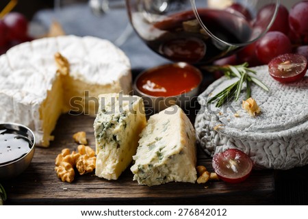 Cheese plate served with wine, jam and honey close-up