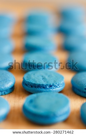 The halfs of french macarons on the wooden table