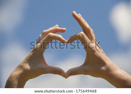 Heart shape hands on the blue sky