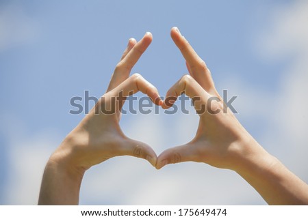 Heart shape hands on the blue sky