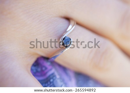 Woman\'s hand wearing a black diamond ring