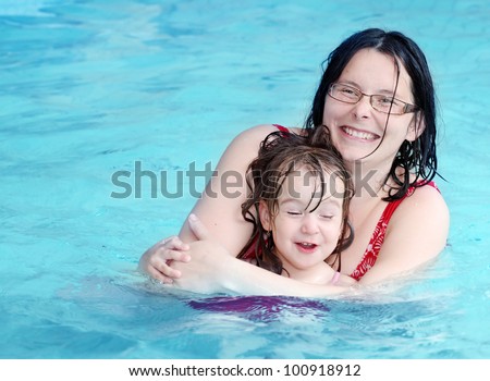 Happy family swimming in a pool.