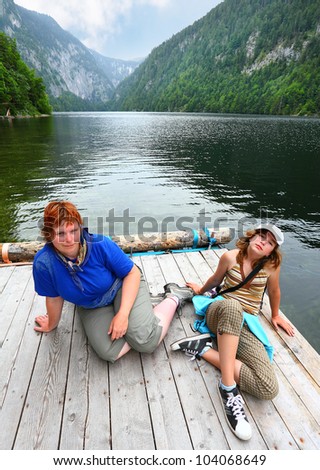 Two tired hikers on a mystic alpine lake Toplitzsee in Salzkammergut, Austria, Europe.