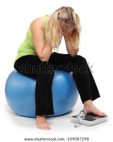 Depressed overweight woman on a weighing machine.