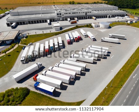 Aerial view of warehouse with trucks. Industrial background. Logistics from above.