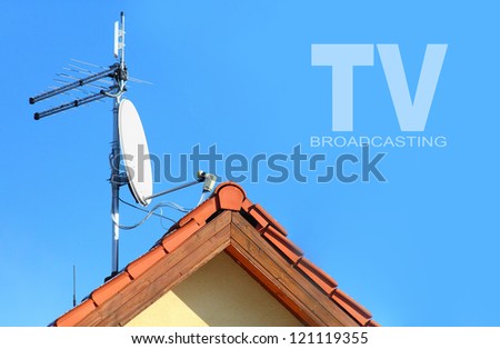 Red roof with a white satellite dish and WiFi antenna. Picture with space for your text.