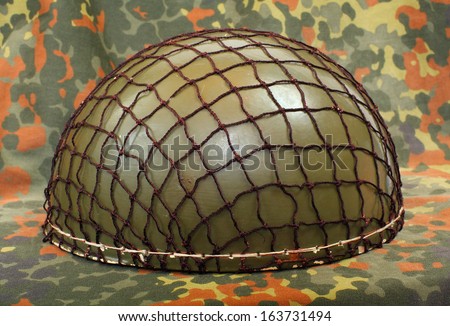 Retro military helmet ( paratrooper\'s helmet) on a camouflage background.