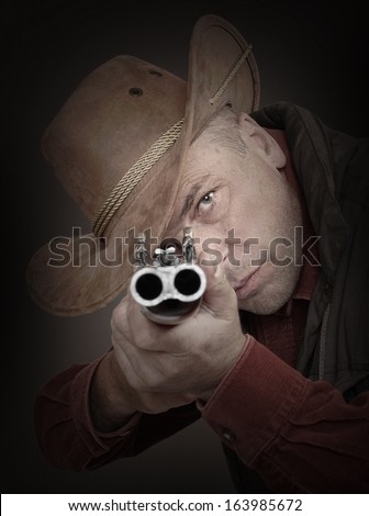 Cowboy with shotgun aiming at you. Gun control concept.