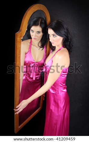 Woman beauty. Young attractive woman in front of mirror. Studio shot.