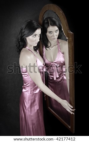 Woman beauty. Young attractive woman in front of mirror. Studio shot.