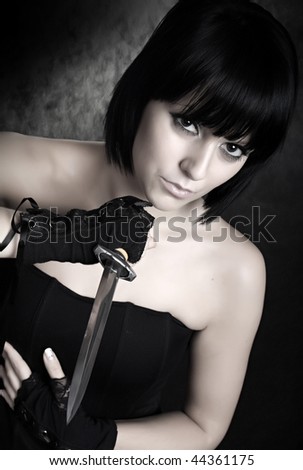 Vogue style photography young beautiful Gothic Girl with sharp dagger. Great for calendar.