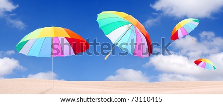 Tropical beach with rainbow umbrellas flying in stormy wind. Stormy weather (end of holidays) metaphor.