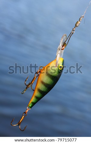 Fishing lure against water level. Close up with shallow DOF.