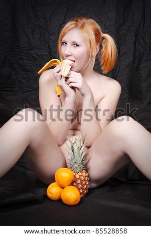 stock photo Naked blonde woman eating fresh ripe bananas on black