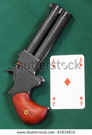 stock photo 45 cal derringer hand gun and ace on a green table