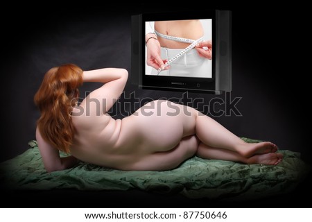 Funny picture of a overweight woman looking at guide to health in the television. Healthy life style metaphor.