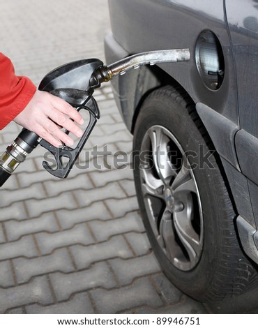 The driver pumping gasoline at the gas station.