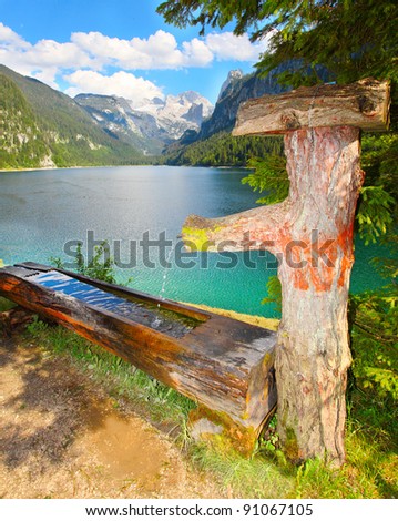 Fountain with drinking water over a Vorderer Gosausee alpine mountain lake in Salzkammergut, Austria, Europe.
