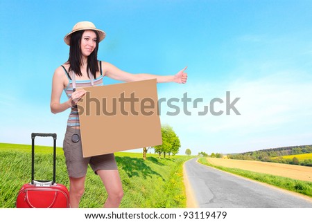 Young hiker with empty sign board on the road. Traveling concept.