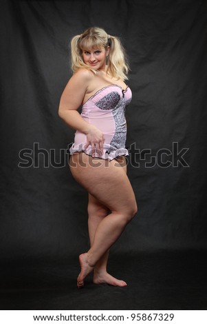 Funny picture of overweight woman dressed in pink lingerie.
