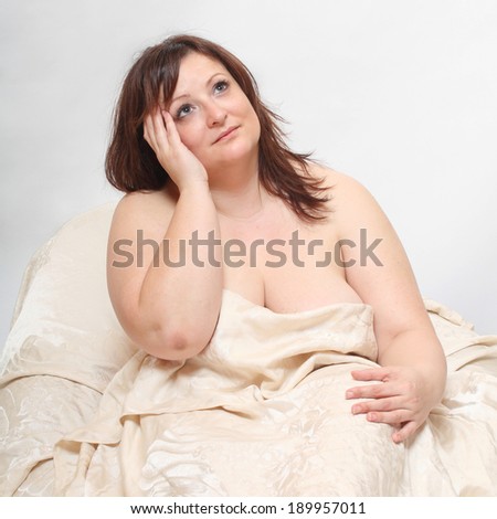 Overweight woman wake up. Early morning in the bedroom.