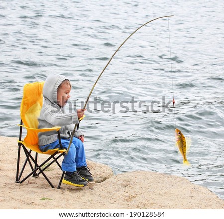 Little boy catching a fish. Happy vacations concept.