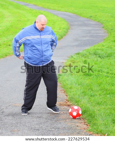 Overweight man training with soccer ball. Weight loss concept.