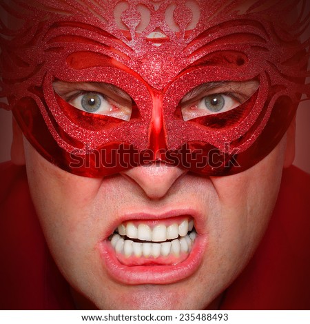 Close up portrait of angry man in red mask. Mental health concept.