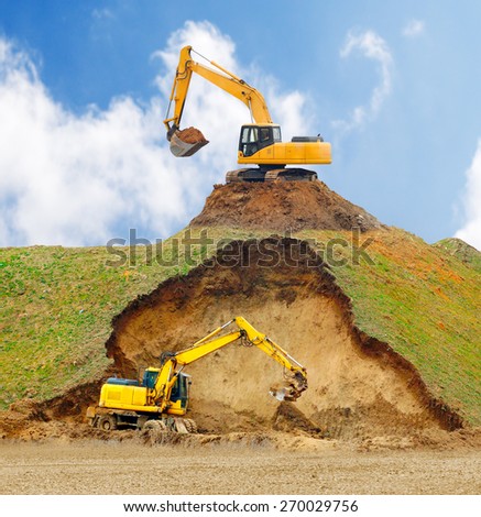 Excavators digging big hole.