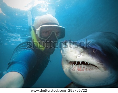 Underwater selfie with friend. Scuba diver and shark in deep sea.