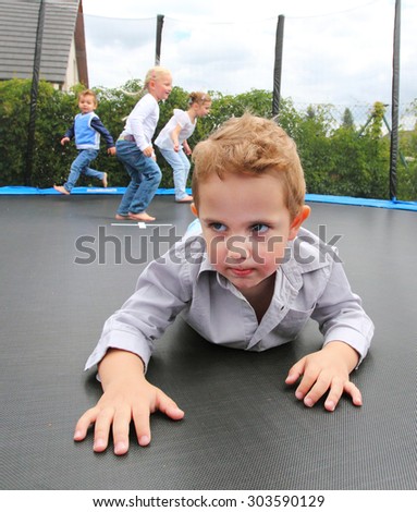 Funny kids playing and jumping on a outdoor trampoline.