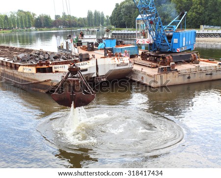 NYMBURK CZECH REPUBLIC - SEPTEMBER 20, 2015: Dredging boat cleaning bottom of Elbe (Labe) River nearby Hydroelectric plant. Very important work for energetic industry and shipping on river.