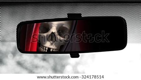 Rear view mirror reflecting Grim Reaper. Road safety theme.