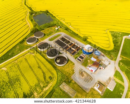Aerial view of biogas plant from pig farm in rapeseed fields. Renewable energy from biomass. Modern agriculture in Czech Republic and European Union.