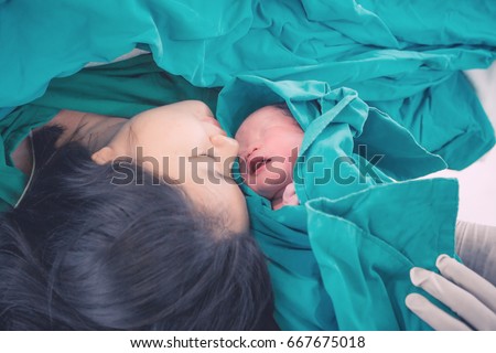 Newborn baby with mother and father in hospital. Newborn child seconds and minutes after birth.